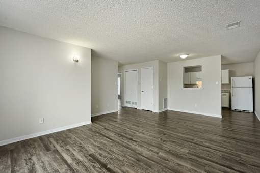 An apartment living room with wood flooring and white walls.