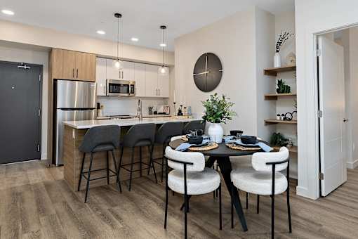 A modern kitchen with a dining table set for four.