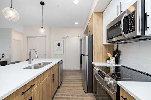 A modern kitchen with wooden cabinets and stainless steel appliances.