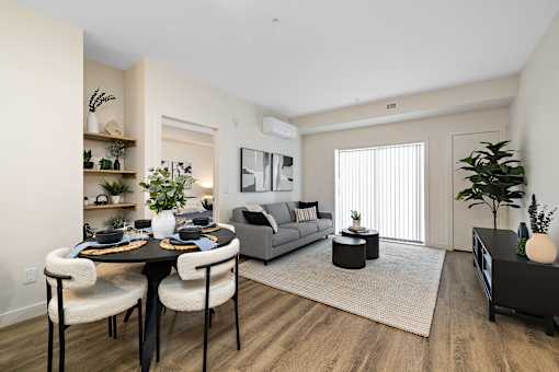 A modern living room with a dining table and chairs.
