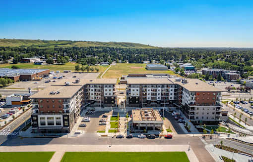 A large building complex with a parking lot in front.
