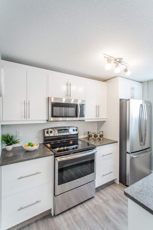 A modern kitchen with stainless steel appliances and white cabinets.