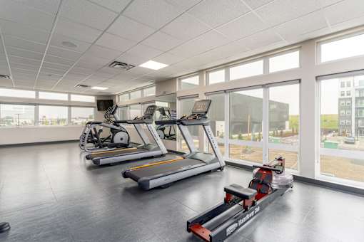 A gym with treadmills and exercise bikes. at G17 Apartments at Tamarack, Edmonton