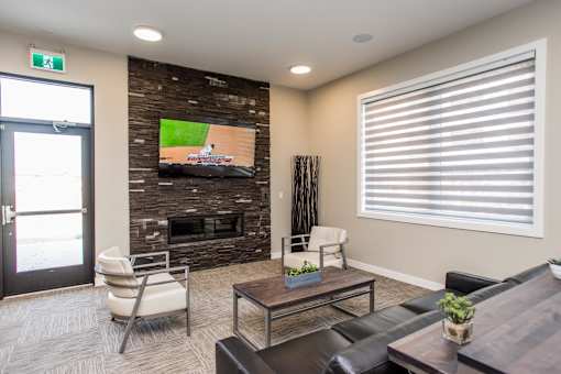 A living room with a flat screen TV mounted on a stone wall.