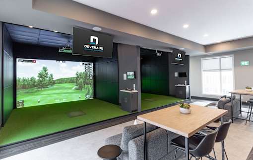A room with a Devarox sign on the wall and a golf simulator.