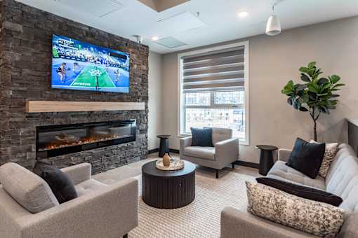 A modern living room with a stone fireplace and a flat screen TV mounted above it.