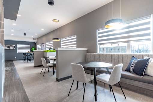 A modern dining area with a table set for four.at Vibe Apartments at Arbour Lake, Alberta, T3G 4J2 