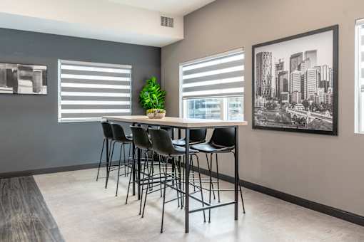 A room with a table and chairs and a picture on the wall.at Vibe Apartments at Arbour Lake, Calgary Alberta  