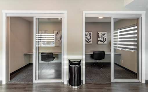 A room with a glass door and a black trash can.at Vibe Apartments at Arbour Lake, Alberta  