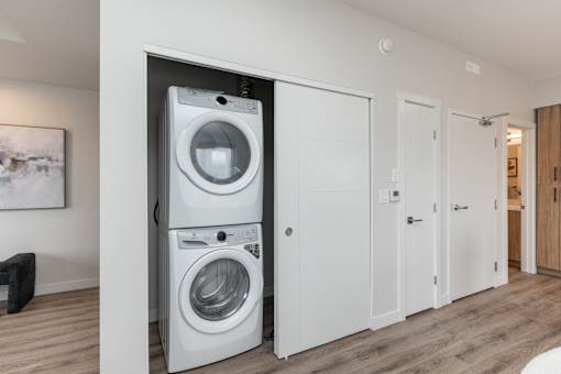 A white washing machine and dryer in a modern laundry room.at Latitude 49 Townhomes, Winnipeg, MB R3X 0M1