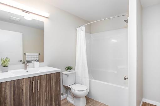 A white bathroom with a toilet, sink, and shower. at G17 Apartments at Tamarack, Edmonton