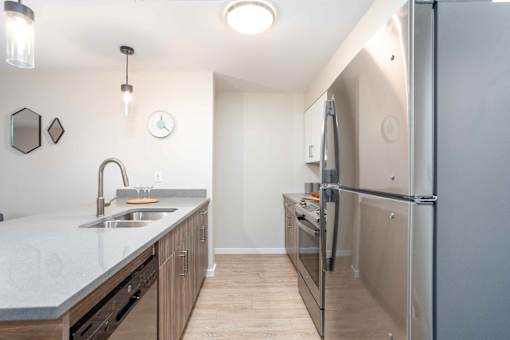 A kitchen with a sink, refrigerator, and cabinets. at G17 Apartments at Tamarack, Edmonton, AB