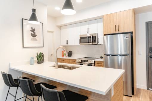 A modern kitchen with a white countertop and stainless steel appliances.