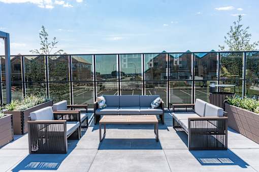 A patio with a glass wall and furniture.