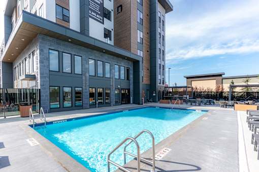 A large swimming pool in front of a multi-story building.