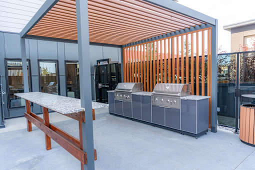 A modern outdoor kitchen with a grill and sink.