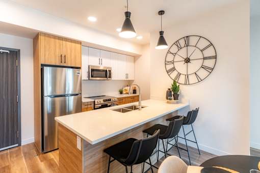A kitchen with a large island and a clock on the wall.