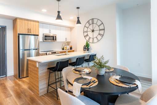 A modern kitchen with a large island and a dining table set for four.