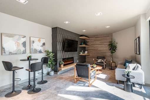 A modern living room with a fireplace and a variety of seating options. at Raymond Block, Edmonton, AB