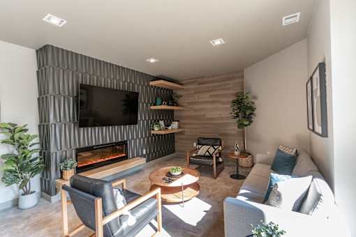 A modern living room with a fireplace and a flat screen TV. at Raymond Block, Edmonton, AB