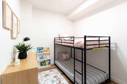 A small room with a bunk bed and a desk.at Podium Apartments, Calgary, AB
