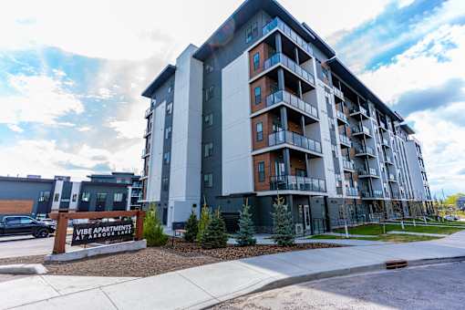 A large apartment building with a sign that says "Vibe Apartments at Argonne Court".