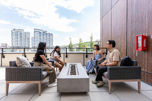 Four people sitting on a patio at Skyway Apartments, Alberta, T3B 5V6