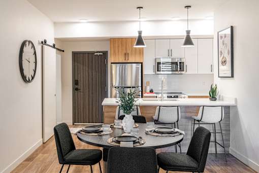 A modern dining room with a round table and chairs.at The Artisan at Rangeview, Calgary, Alberta