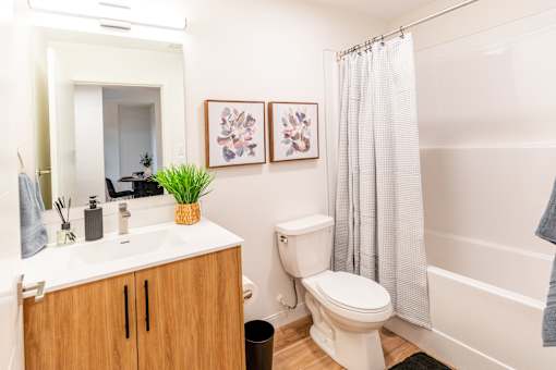 A bathroom with a toilet, sink, and shower.at The Artisan at Rangeview, Calgary, Alberta