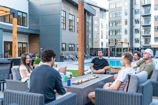 A Group Of People Are Sitting Around a Table Outside at Podium Apartments, Calgary, AB