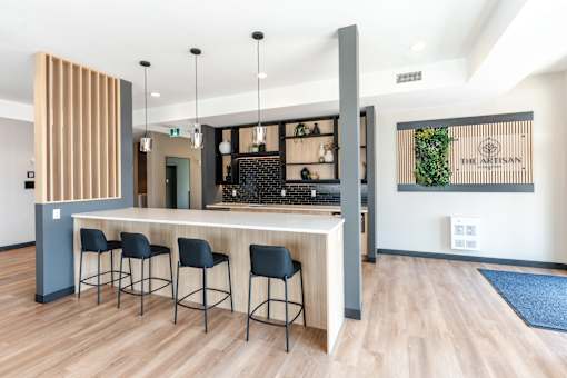 A bar area with a wooden counter and stools.