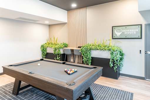 A pool table with a green cloth and balls in the middle of it.