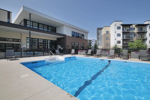 a large swimming pool in front of an apartment building