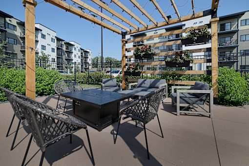 A patio with a table and chairs under a pergola.