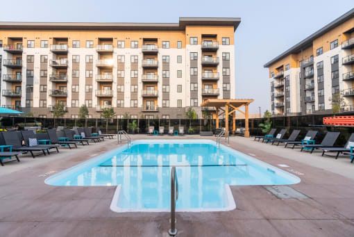 a swimming pool in front of an apartment building at Vibe Apartments at Arbour Lake in Calgary, AB