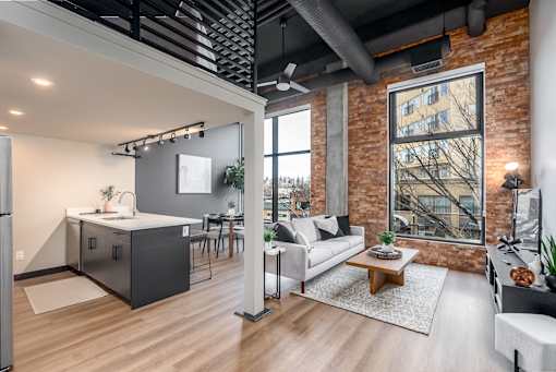 A modern kitchen with a refrigerator, sink, and a dining table with chairs.at Raymond Block, Edmonton