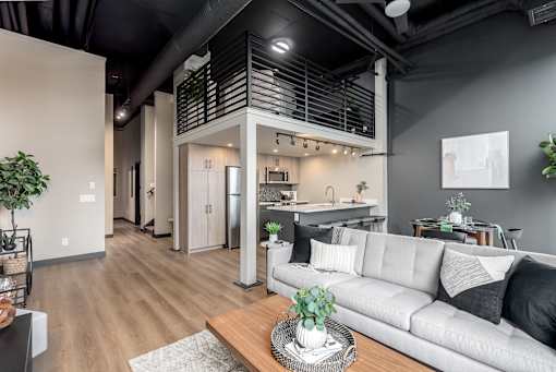A modern living room with a grey sofa and a wooden coffee table.at Raymond Block, Edmonton, AB
