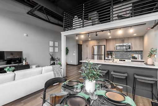 A modern dining area with a table set for a meal.at Raymond Block, Edmonton, T6E 3R7
