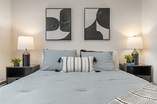a bedroom with a bed and two paintings on the wall