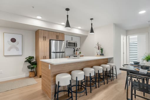 an open kitchen and dining area with a bar and stools