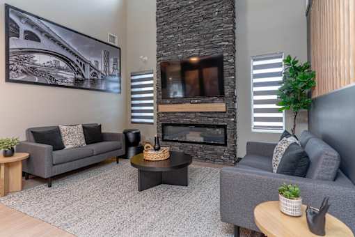 A living room with a grey couch, a coffee table, and a fireplace.