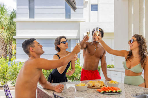 A group of people toasting with champagne at a barbecue.at Icon One, Florida, 32114