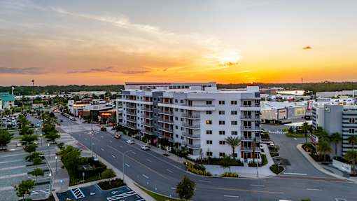 A sunset view of a street with cars and buildings.at Icon One, Daytona Beach, 32114