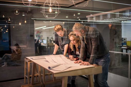 Business professionals viewing plans on a table