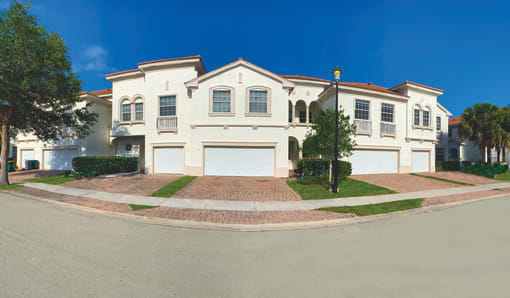 a large white house on the corner of a street at The Falls of Portofino, Naples, FL, 34119