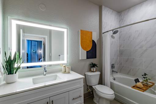 A bathroom with a white sink, toilet, and bathtub.at Icon One, Daytona Beach, Florida
