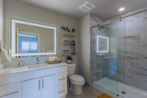 A bathroom with a marble tile shower and a white toilet.at Icon One, Daytona Beach, FL, 32114