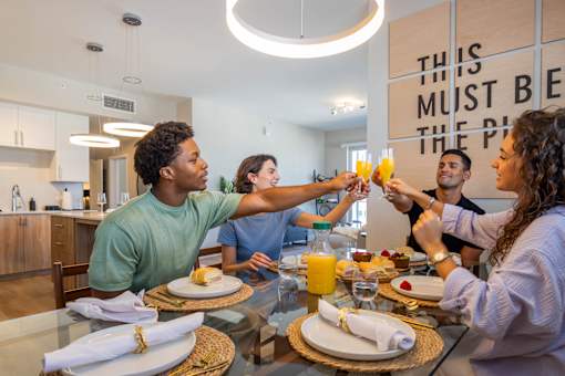 A group of people toasting with drinks at a dinner table.at Icon One, Daytona Beach, Florida