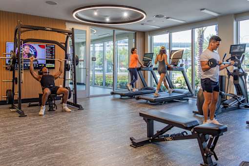 A man is working out on a machine in a gym with other people exercising in the background.at Icon One, Florida, 32114