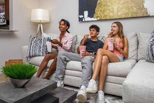 Three people are sitting on a couch at Portofino Cove, Fort Myers, Florida